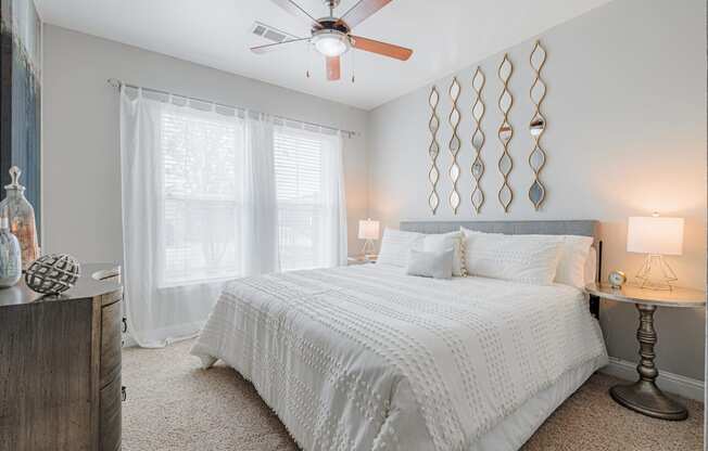 a bedroom with a large bed and a ceiling fan