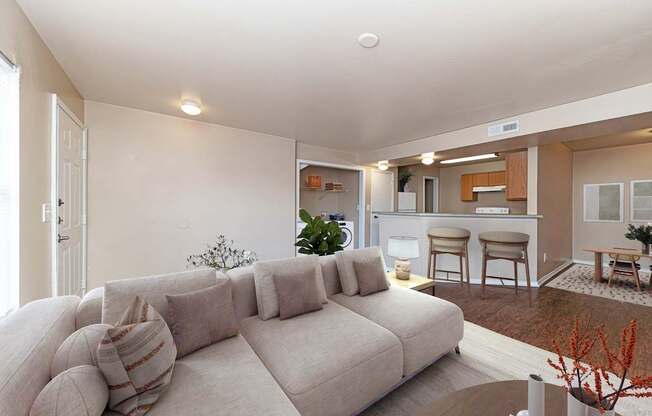 A living room with a large couch and a dining area in the background.