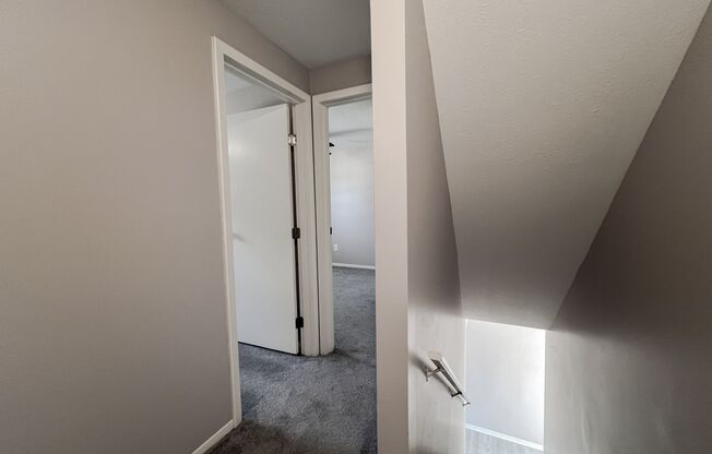 an empty room with a closet and a door to a hallway