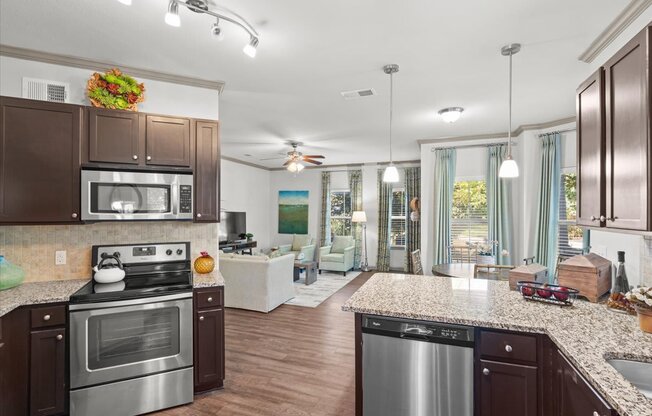 a kitchen and living room with wood floors and a ceiling fan