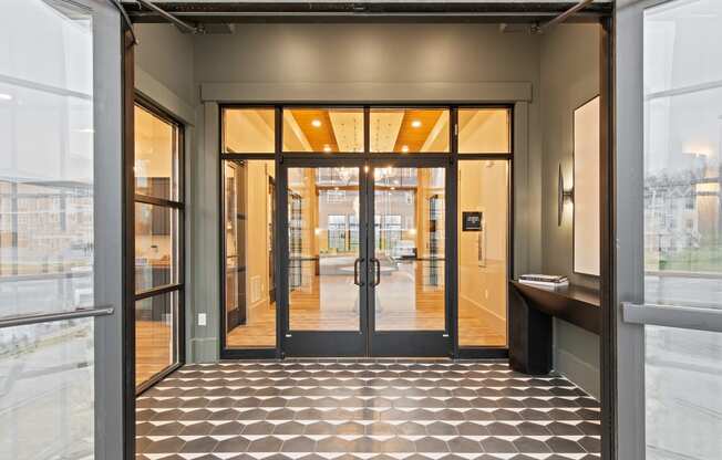 Lobby of a building with glass doors and a tiled floor at Hadley Place Apartments, Enola