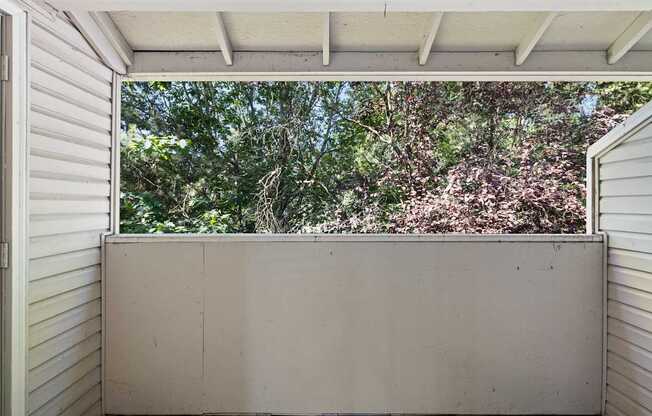 A view of trees through an apartment deck at Clackamas Trails Apartments, Oregon, 97222