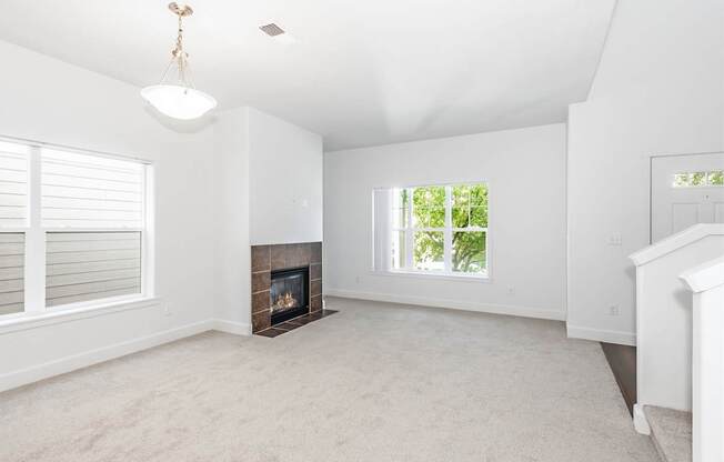 A living room with a fireplace and a window at The Landing Apartments and Townhomes, Oregon, 97045