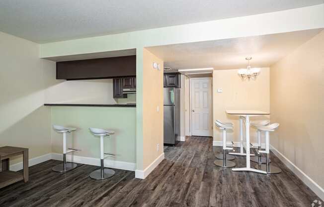 a living room with a bar and a kitchen in the background