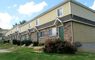 tan exterior of town homes with shrubbery out front