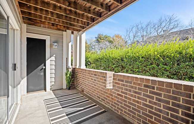 A house entrance with a striped rug on the ground.