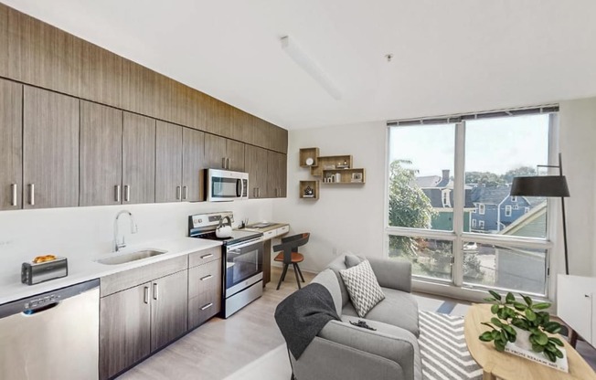 a living room with a kitchen and a large window