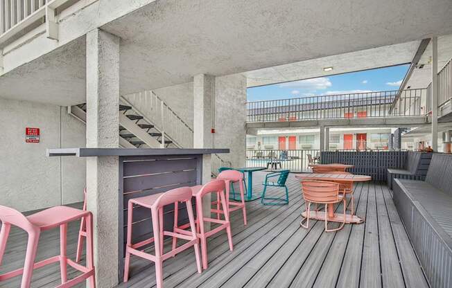 A patio with a bar and chairs.