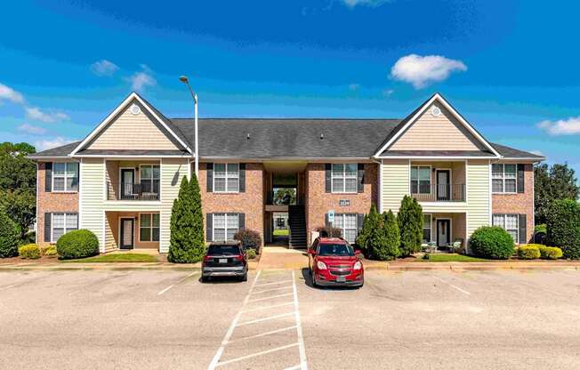 an apartment building with two cars parked in front of it