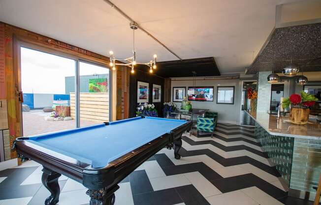 a pool table in a living room with a view of the ocean