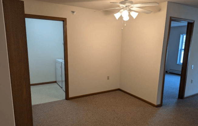 an empty room with a ceiling fan and a closet