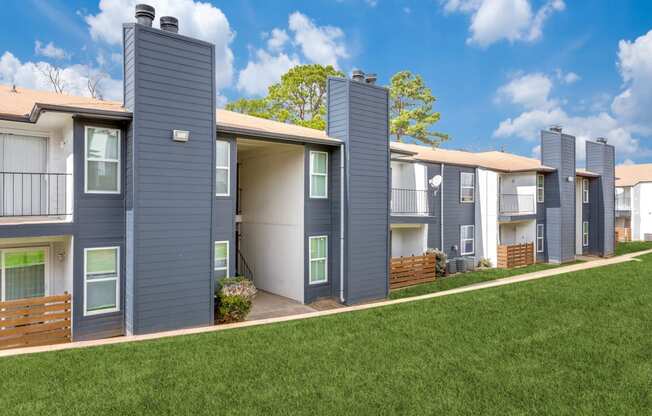 a row of townhomes with gray roofs and green grass