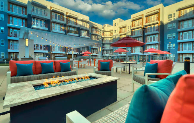 a seating area with couches and tables with umbrellas and a fire pit at The Rey Downtown, Arizona