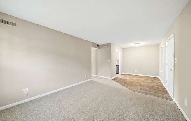 A room with a carpeted floor and a door on the right side.