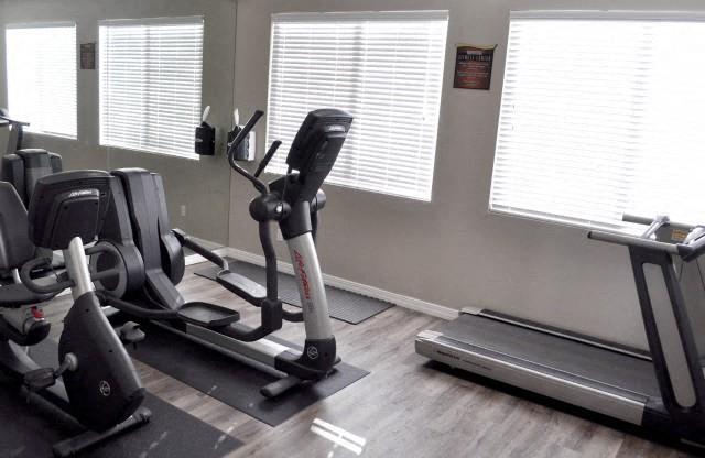 North Creek Apartments Fitness Center with grey hardwood-style floors, elliptical, bike & treadmill