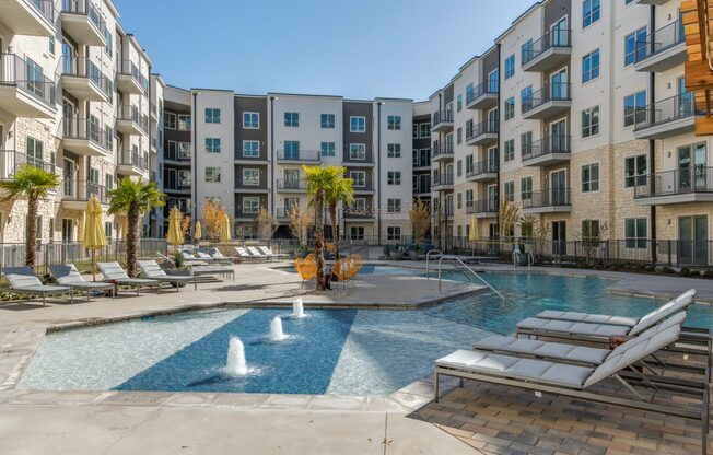 A pool with a fountain in the middle of it.