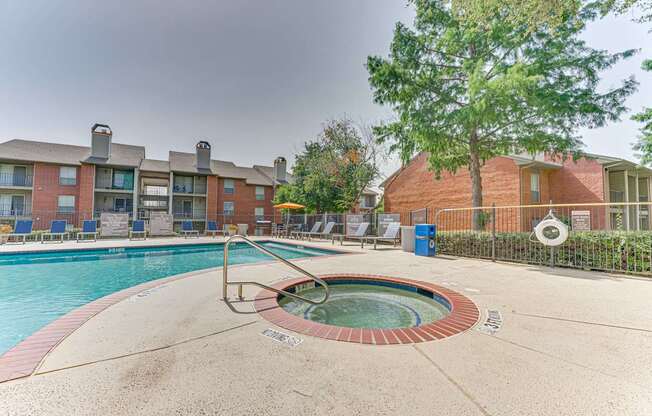 A swimming pool with a hot tub in the middle of it at Copper Hill Apartments, Texas