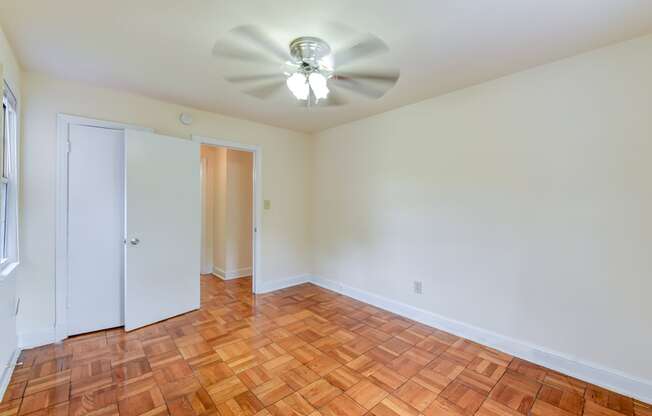 vacant bedroom with hardwood flooring and ceiling fan at colonnade apartments in washington dc