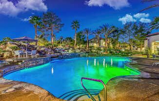 A pool with a chair in the foreground and a house in the background.