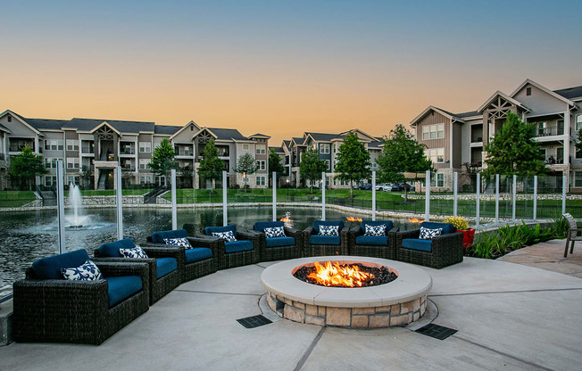 Cozy Firepit and Outdoor Lounge Seating by Lake at Houston Apartment Complex
