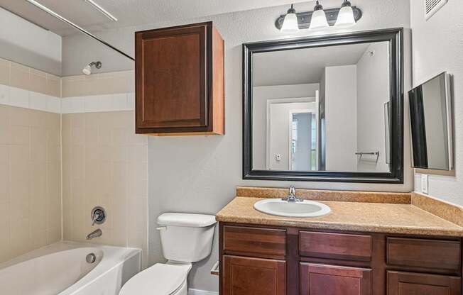 A bathroom with a white tub, toilet, and sink.