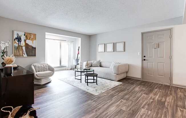 A living room with a brown wooden floor and a white ceiling.