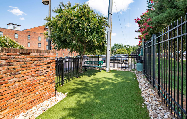 a yard with a bench in front of a black fence