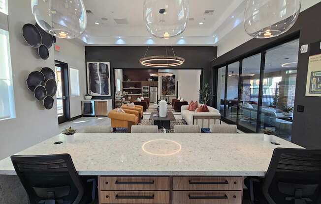 A modern kitchen with a large island and black chairs.