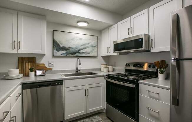 a kitchen with stainless steel appliances and white cabinets