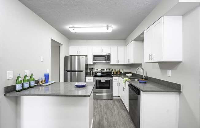 a kitchen with white cabinets and stainless steel appliances