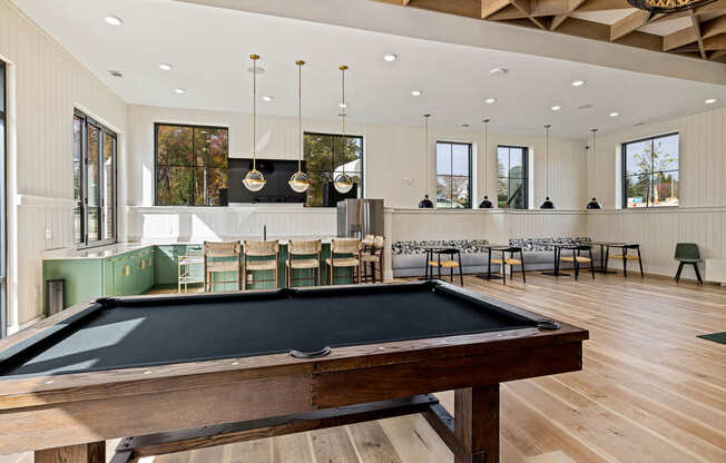 A billiard table is in the middle of a room with a pool table.