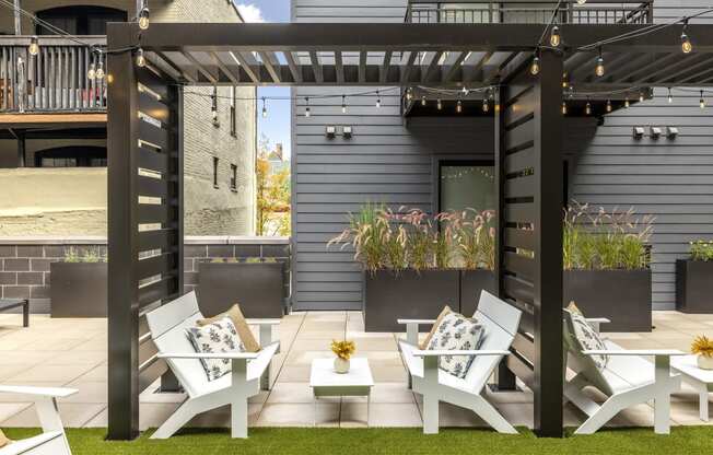 a group of white lounge chairs and tables on a patio