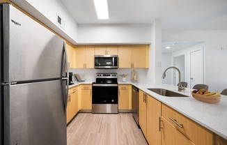 an empty kitchen with wooden cabinets and stainless steel appliances