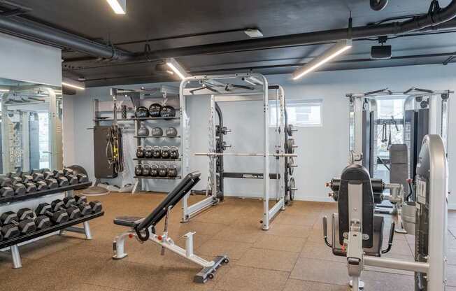 A gym with a variety of equipment including weights and weight machines.