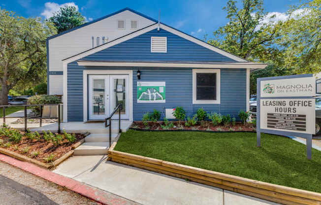 a blue house with a white sign in front of it