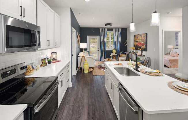 A modern kitchen with dark wood floors and white cabinetry.
