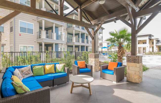 A patio with a blue couch and a wooden table.