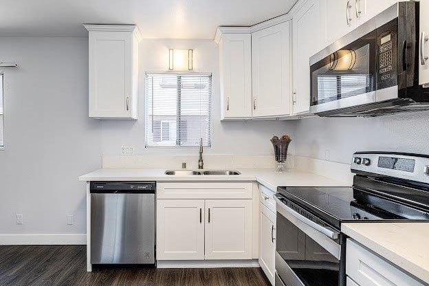 A kitchen with white cabinets and black appliances.