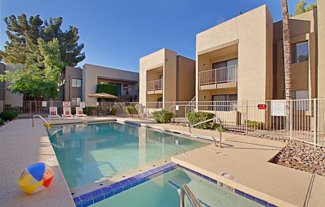 a swimming pool with a beach ball in front of a building