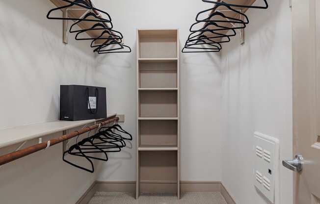a walk in closet with a shoe rack on the wall and a closet with shelves