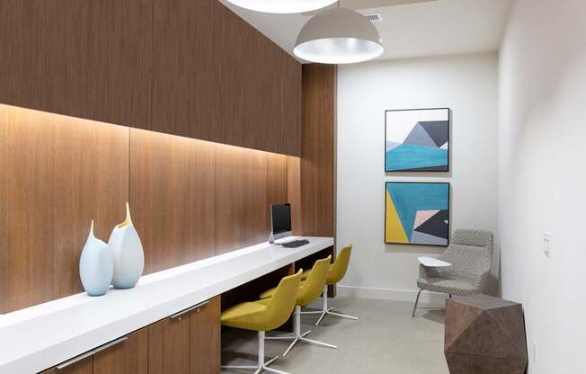 A room with a white desk, yellow chairs, and a brown wall.