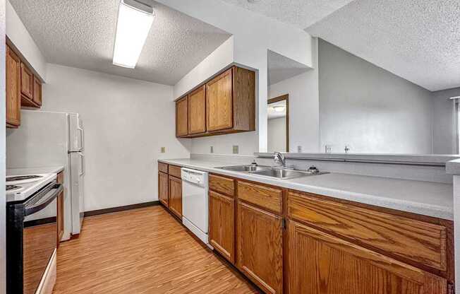 a kitchen with wooden cabinets and a sink and a refrigerator