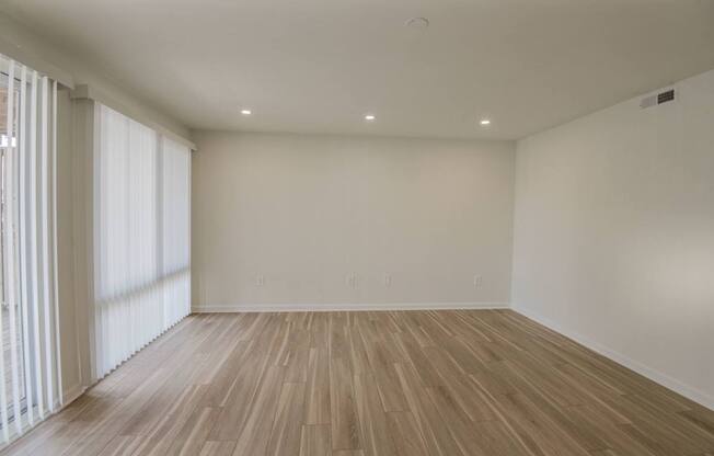 A room with wooden flooring and white walls.