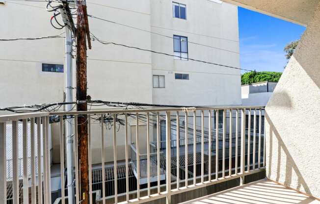 a balcony with a metal railing and a building in the background