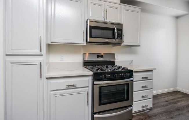 a kitchen with white cabinets and stainless steel appliances