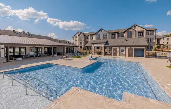 A large swimming pool in front of a residential building.at Evolve at Parkway Apartment Homes, Concord North Carolina
