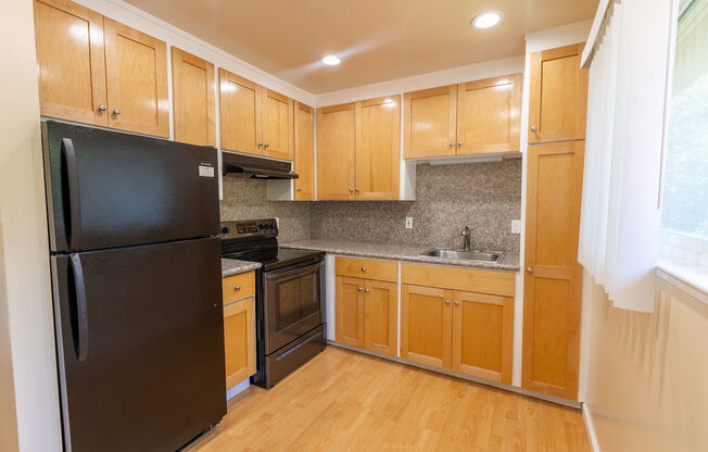 a kitchen with black appliances and wooden cabinets