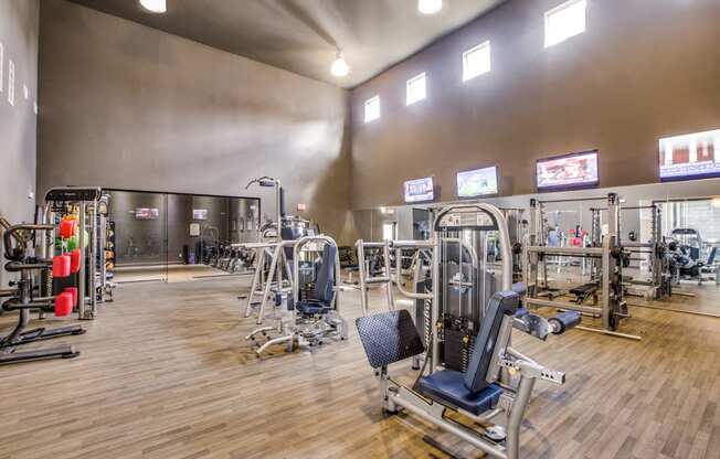 a gym with cardio machines and weights on a wooden floor at Volare at the Woodlands, The Woodlands, 77384