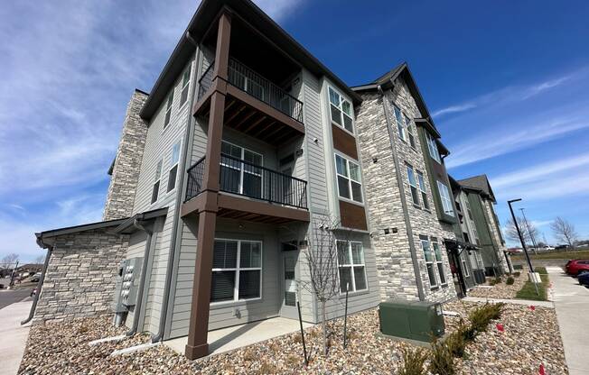 an apartment building with stone facade and balconies on a sunny day at The Depot, Missouri