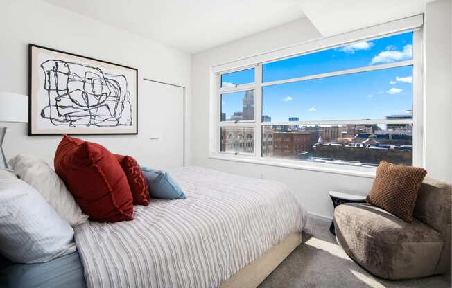 a bedroom with a bed and a large window